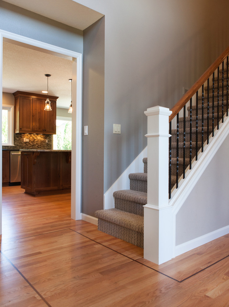 Ejemplo de escalera recta rústica de tamaño medio con escalones enmoquetados, contrahuellas enmoquetadas y barandilla de madera