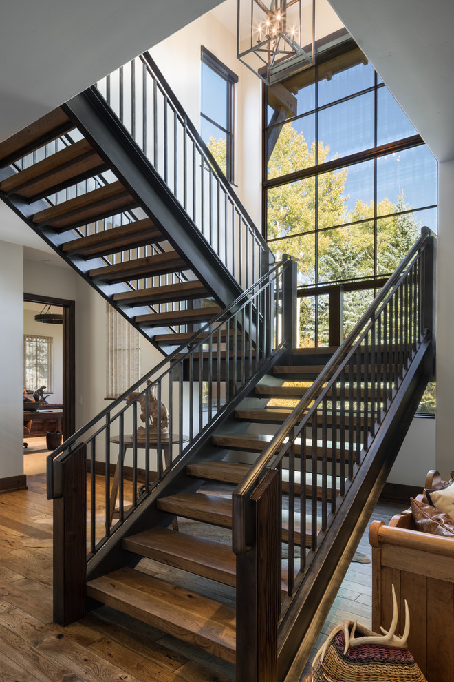 Foto de escalera en U rústica sin contrahuella con escalones de madera y barandilla de metal