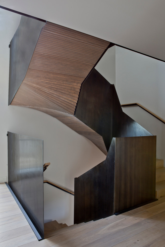 Foto de escalera curva actual con escalones de madera y contrahuellas de madera