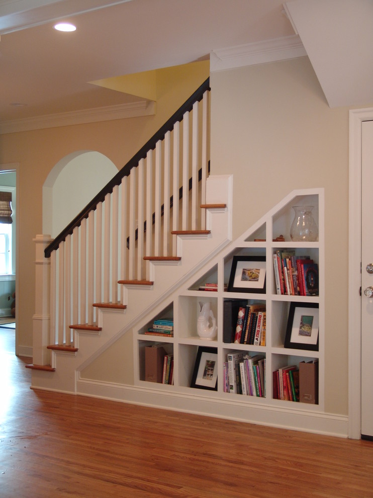 На фото: лестница в классическом стиле с кладовкой или шкафом под ней с
