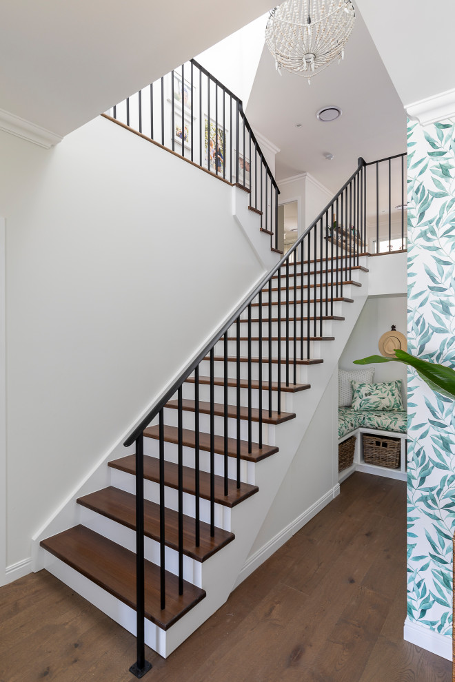 This is an example of a medium sized traditional wood straight metal railing staircase in Brisbane with painted wood risers.
