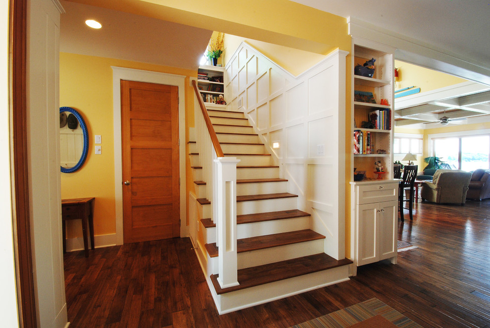 This is an example of a small beach style wood straight wood railing staircase in Kansas City with wood risers and feature lighting.
