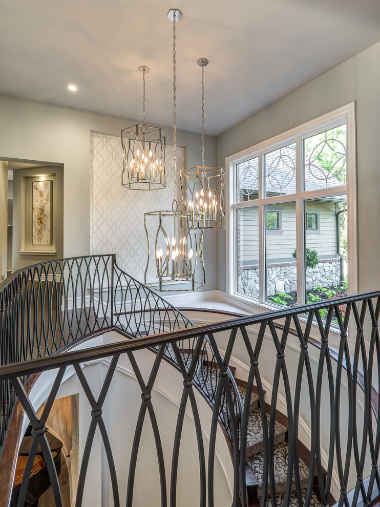 Example of a huge transitional carpeted curved metal railing staircase design in Cincinnati with carpeted risers