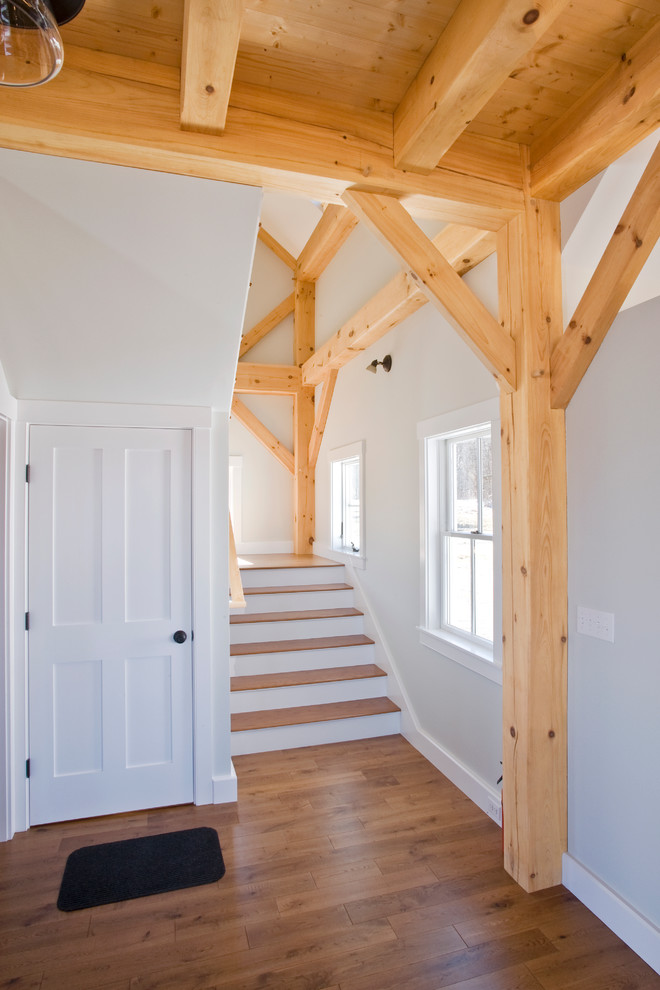 Foto de escalera recta clásica de tamaño medio con escalones de madera, contrahuellas de madera pintada y barandilla de madera