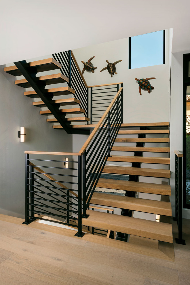 Inspiration pour un grand escalier sans contremarche marin en U avec des marches en bois et un garde-corps en métal.