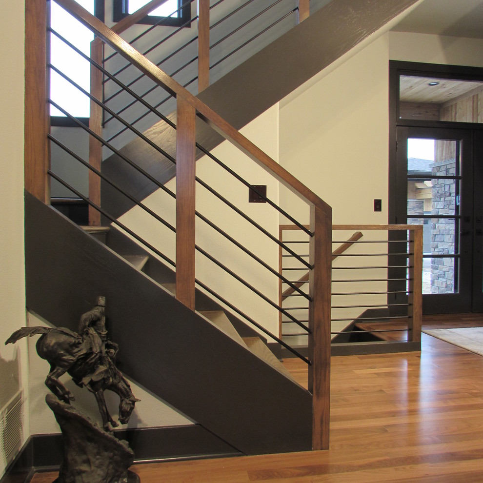 Ejemplo de escalera en U urbana de tamaño medio con escalones de madera, contrahuellas de madera y barandilla de metal