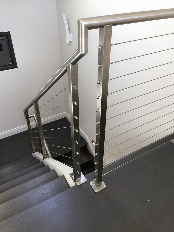 Imagen de escalera en U minimalista de tamaño medio con escalones de madera, contrahuellas de madera y barandilla de cable
