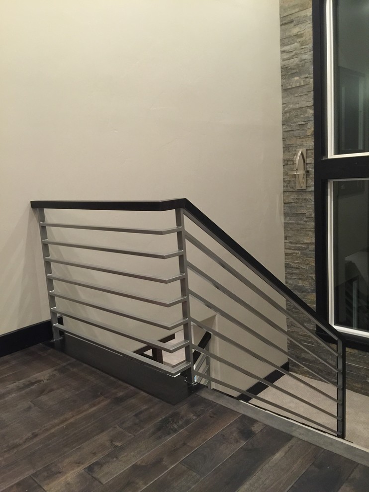 ソルトレイクシティにある高級な広いコンテンポラリースタイルのおしゃれな折り返し階段 (木の蹴込み板) の写真