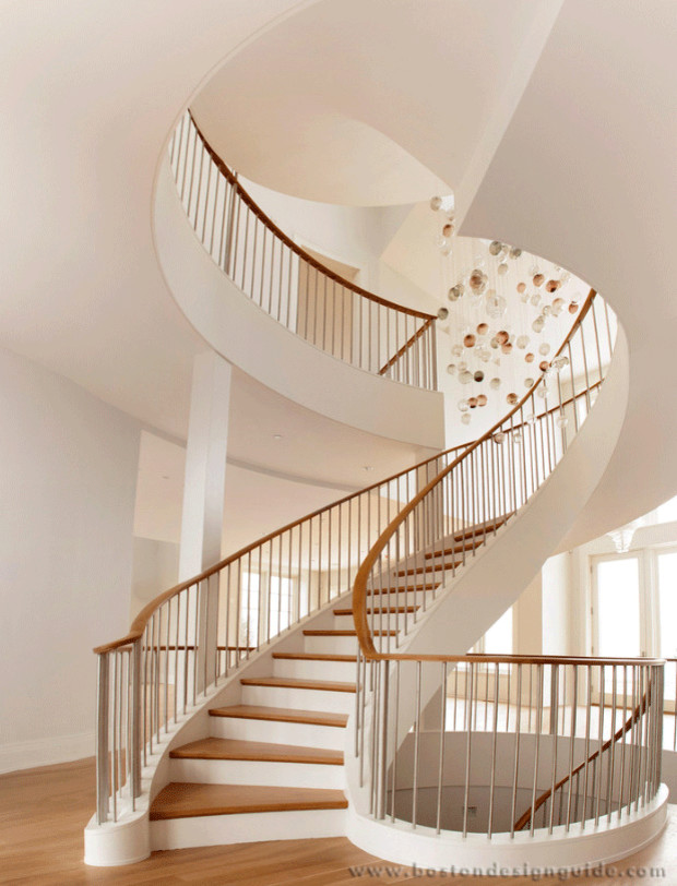 This is an example of an expansive contemporary wood spiral staircase in Boston with metal risers.