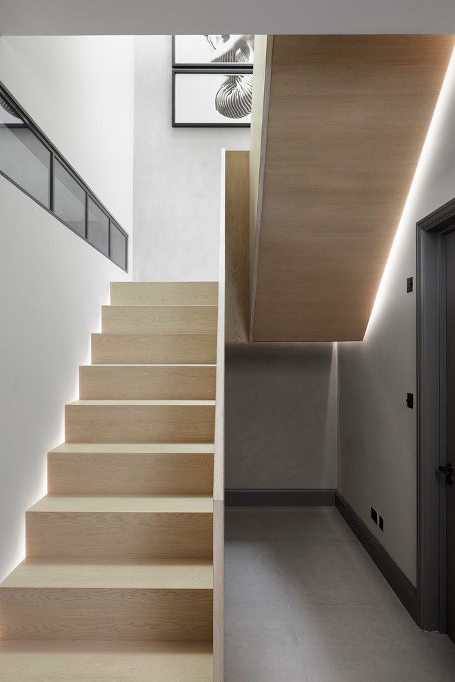 На фото: п-образная деревянная лестница среднего размера в современном стиле с деревянными ступенями и деревянными перилами с