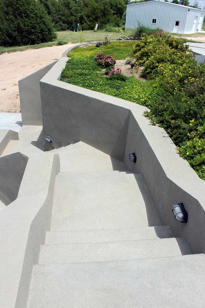 Aménagement d'un grand escalier courbe éclectique en béton avec des contremarches en béton et un garde-corps en matériaux mixtes.