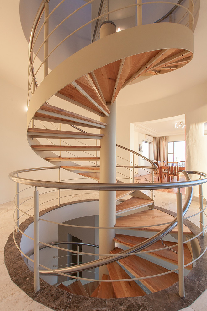 Exemple d'un très grand escalier sans contremarche hélicoïdal tendance avec des marches en bois.