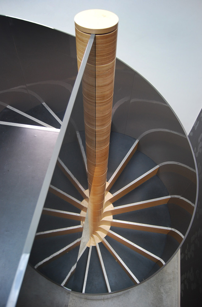 Inspiration for a large contemporary wood spiral staircase in London with wood risers.