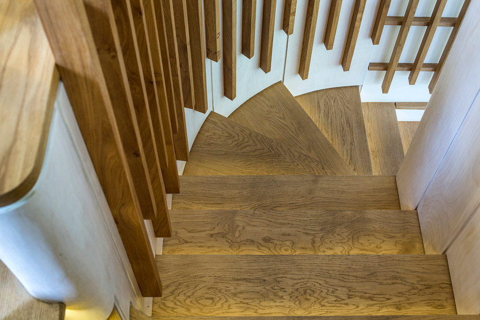 Exemple d'un escalier courbe tendance de taille moyenne avec des marches en bois et des contremarches en bois.
