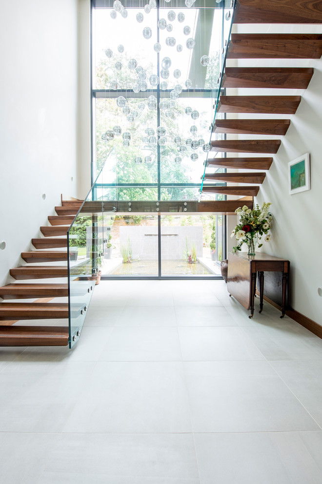 This is an example of a contemporary wood floating staircase in Dorset with open risers.