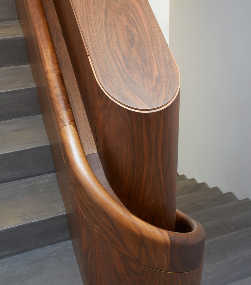 Inspiration for a huge contemporary concrete u-shaped wood railing staircase remodel in Other with concrete risers