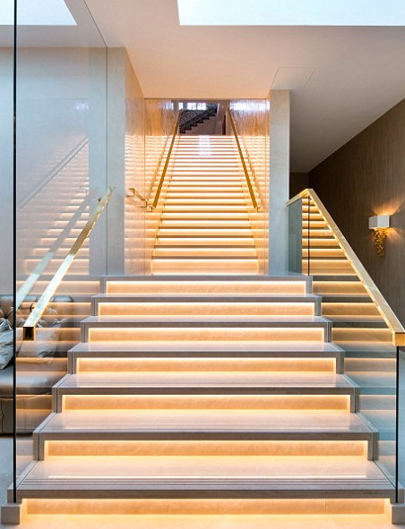 ロンドンにあるラグジュアリーな巨大なコンテンポラリースタイルのおしゃれな直階段 (ガラスの蹴込み板) の写真