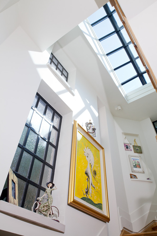 Imagen de escalera suspendida ecléctica grande con escalones de madera, contrahuellas de madera y barandilla de varios materiales