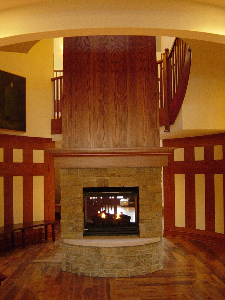 На фото: огромная деревянная лестница на больцах в стиле фьюжн с деревянными ступенями и деревянными перилами с