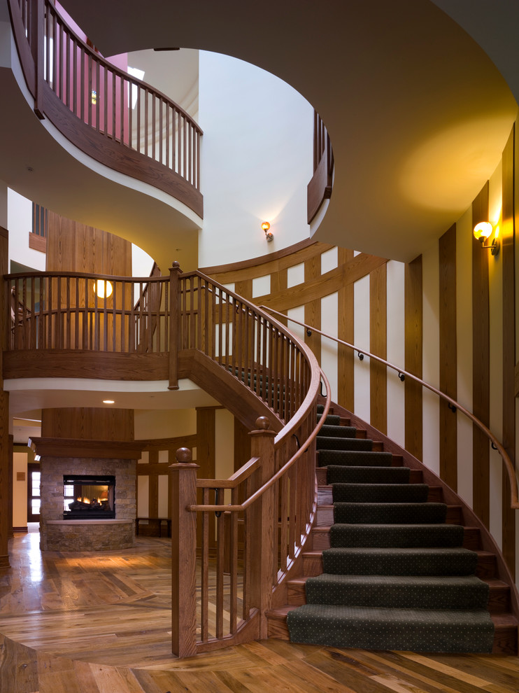 Idée de décoration pour un très grand escalier flottant bohème avec des marches en bois, des contremarches en bois et un garde-corps en bois.