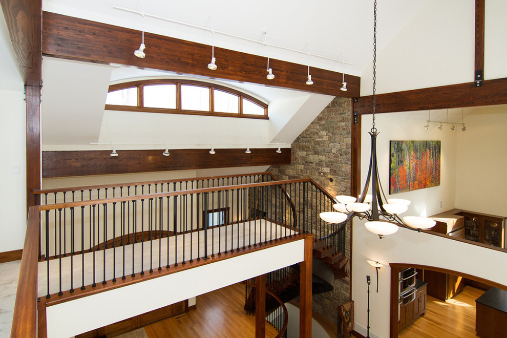 Cette image montre un grand escalier sans contremarche courbe bohème avec des marches en bois.