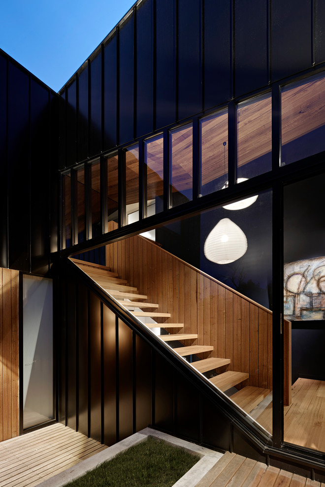 Réalisation d'un grand escalier sans contremarche droit minimaliste avec des marches en bois et un garde-corps en bois.