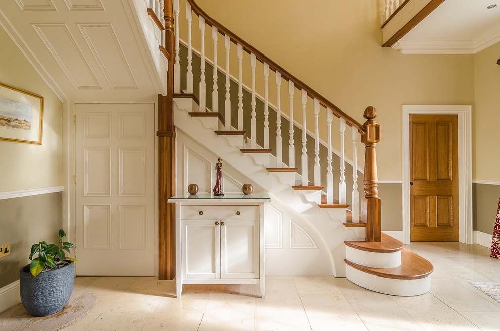 Idée de décoration pour un escalier peint tradition en L avec des marches en bois et rangements.
