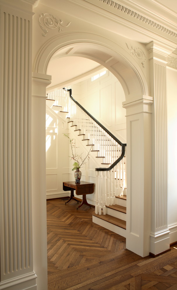 Идея дизайна: большая п-образная лестница в классическом стиле с деревянными ступенями и крашенными деревянными подступенками