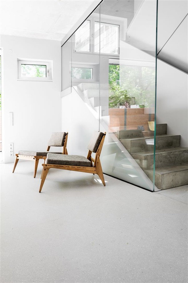 Réalisation d'un escalier minimaliste en U et béton de taille moyenne avec des contremarches en béton et un garde-corps en verre.