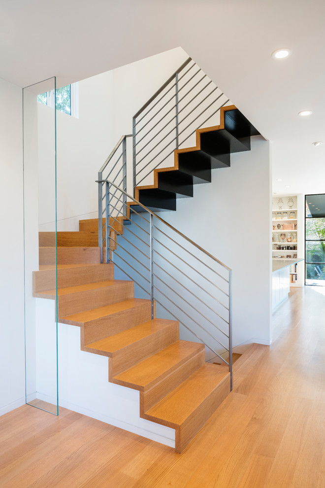 На фото: лестница на больцах, среднего размера в стиле модернизм с деревянными ступенями и металлическими перилами без подступенок