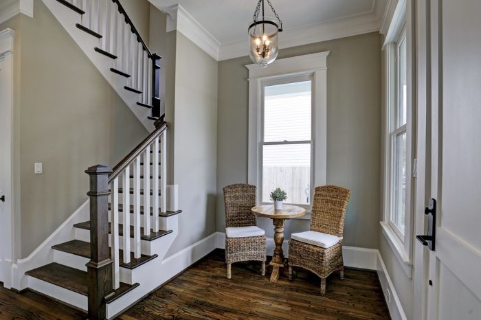 Diseño de escalera en U de estilo americano de tamaño medio con escalones de madera, contrahuellas de madera pintada y barandilla de madera