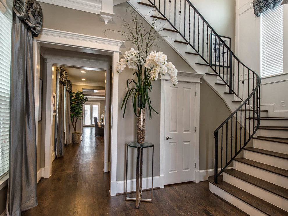 This is an example of a medium sized traditional wood curved metal railing staircase in Houston with painted wood risers.