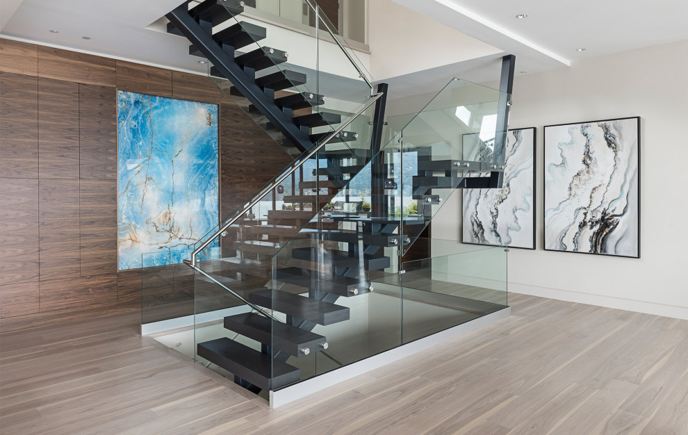 Photo of a medium sized contemporary floating glass railing staircase in Vancouver with open risers.