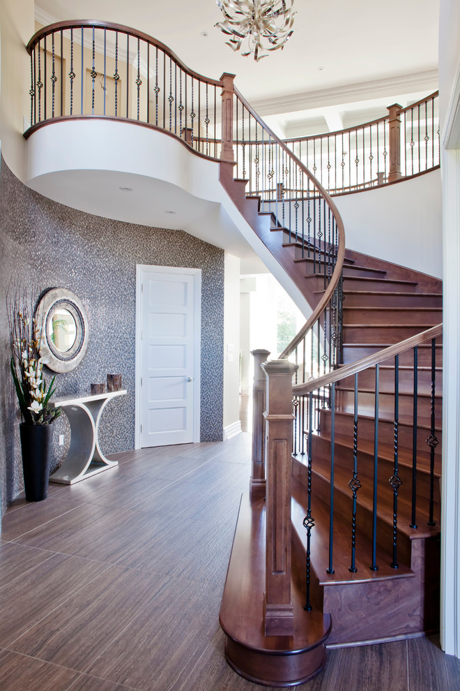 Inspiration for a classic wood curved metal railing staircase in Montreal with wood risers.