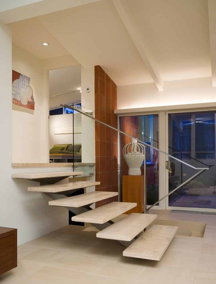 Идея дизайна: лестница в стиле модернизм с ступенями из травертина и металлическими перилами без подступенок