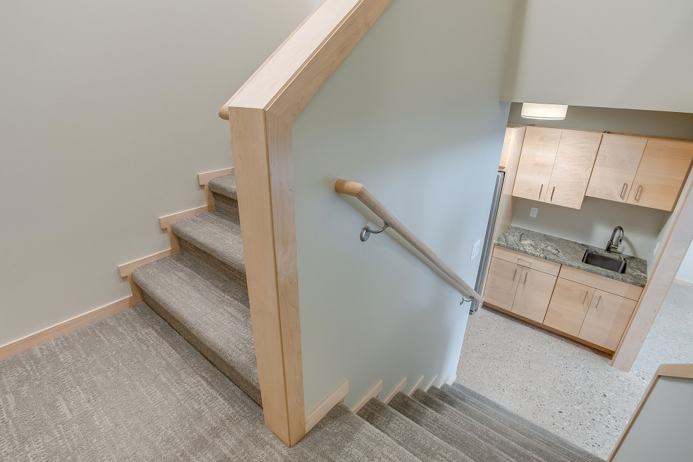 Diseño de escalera en U rústica de tamaño medio con escalones enmoquetados, contrahuellas enmoquetadas y barandilla de madera