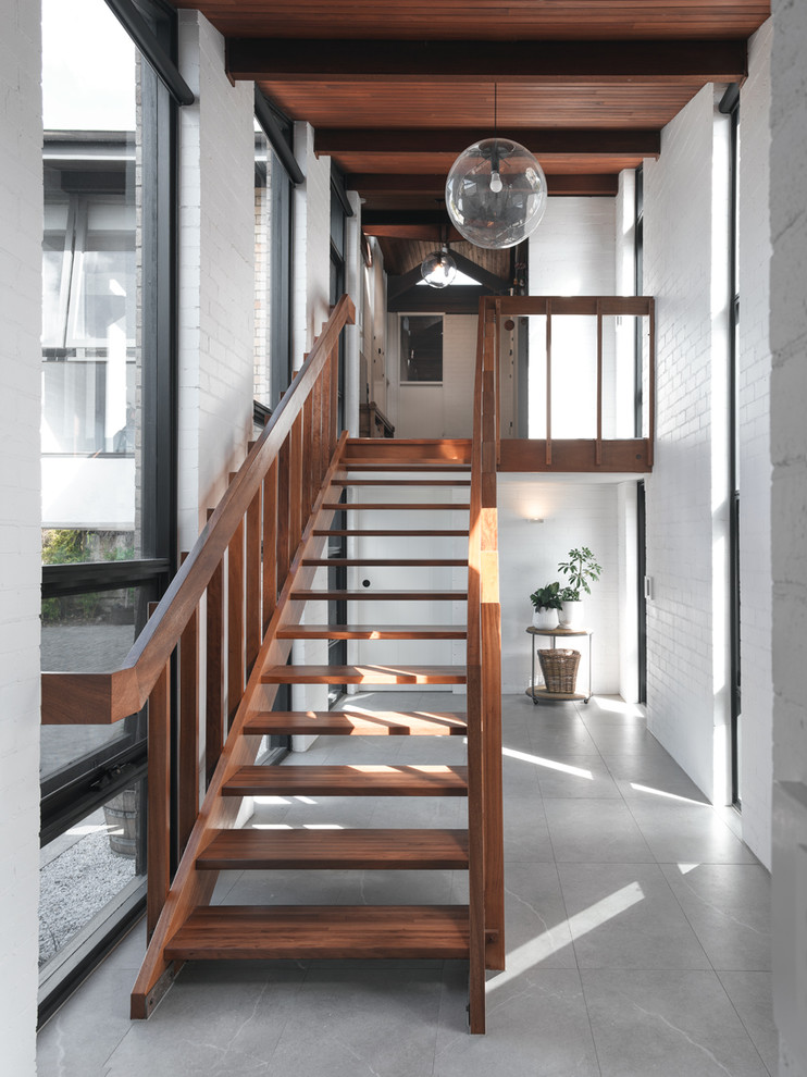 Imagen de escalera recta retro grande sin contrahuella con escalones de madera y barandilla de madera