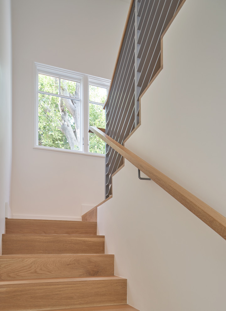 На фото: п-образная деревянная лестница среднего размера в стиле кантри с деревянными ступенями и металлическими перилами с
