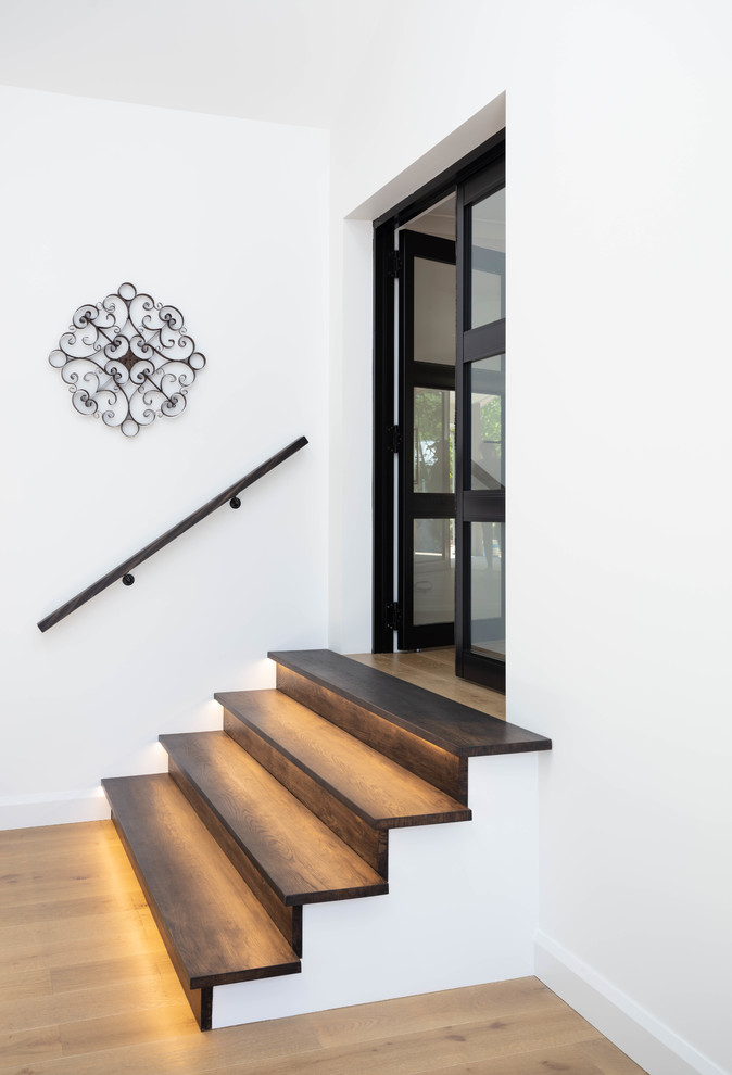 Foto de escalera recta actual con escalones de madera, contrahuellas de madera y barandilla de madera