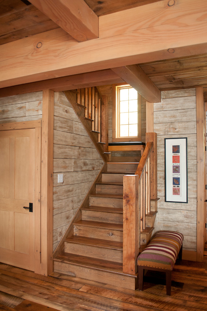 Photo of a rustic wood l-shaped wood railing staircase in Other with wood risers.