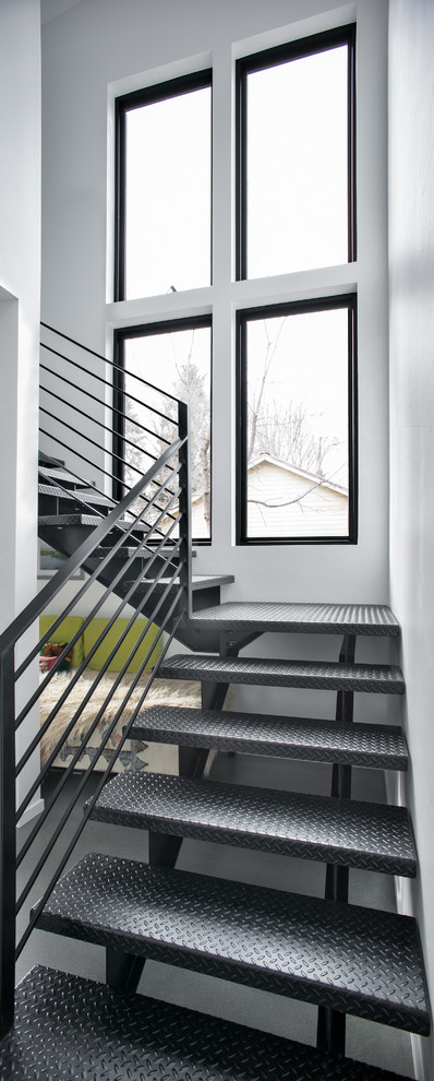Cette photo montre un escalier tendance en L de taille moyenne avec des marches en métal, des contremarches en métal et un garde-corps en métal.