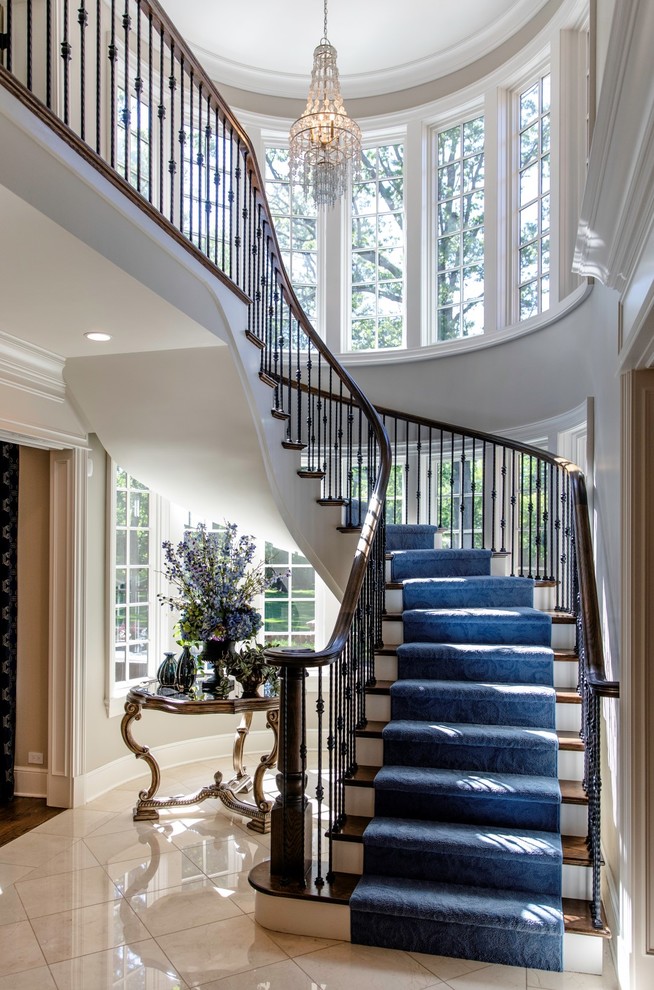 Inspiration for a large classic wood curved metal railing staircase in Chicago with wood risers.