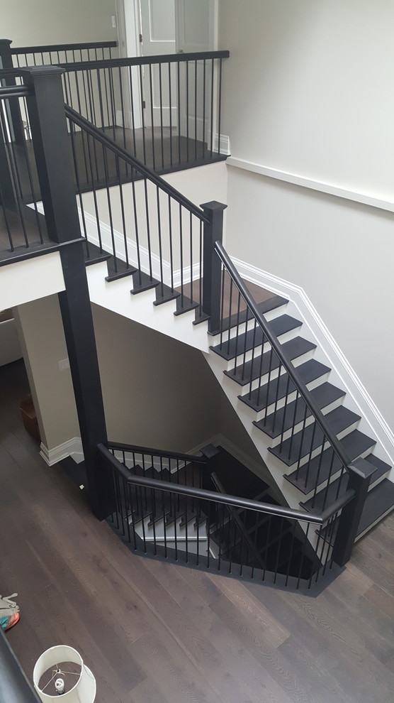 This is an example of a large classic wood l-shaped wood railing staircase in Toronto with painted wood risers.