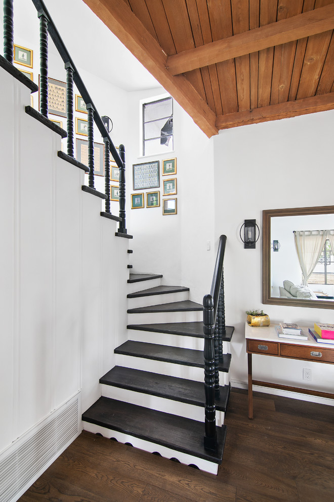 Diseño de escalera curva tradicional renovada con escalones de madera pintada, contrahuellas de madera pintada y barandilla de madera