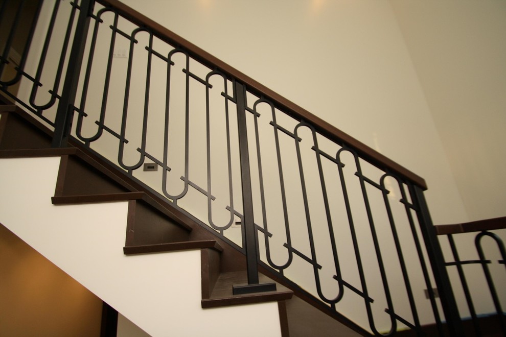 Cette image montre un grand escalier peint droit traditionnel avec des marches en bois peint.