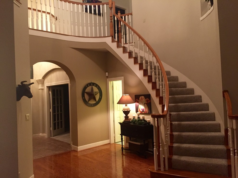 Пример оригинального дизайна: изогнутая лестница среднего размера в стиле фьюжн с ступенями с ковровым покрытием и ковровыми подступенками