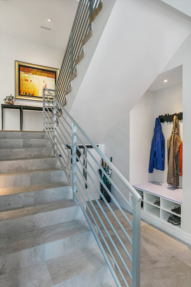 Imagen de escalera curva actual de tamaño medio con escalones con baldosas, contrahuellas con baldosas y/o azulejos y barandilla de metal