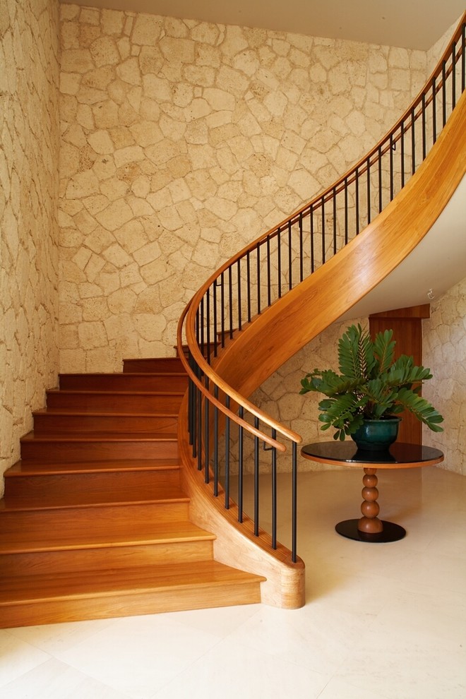 Foto de escalera curva exótica con escalones de madera y contrahuellas de madera