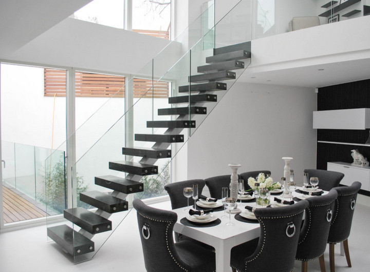 Ejemplo de escalera en L minimalista de tamaño medio sin contrahuella con escalones de madera pintada y barandilla de vidrio