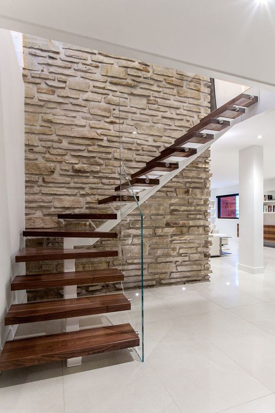 Diseño de escalera en L moderna de tamaño medio sin contrahuella con barandilla de vidrio y escalones de madera